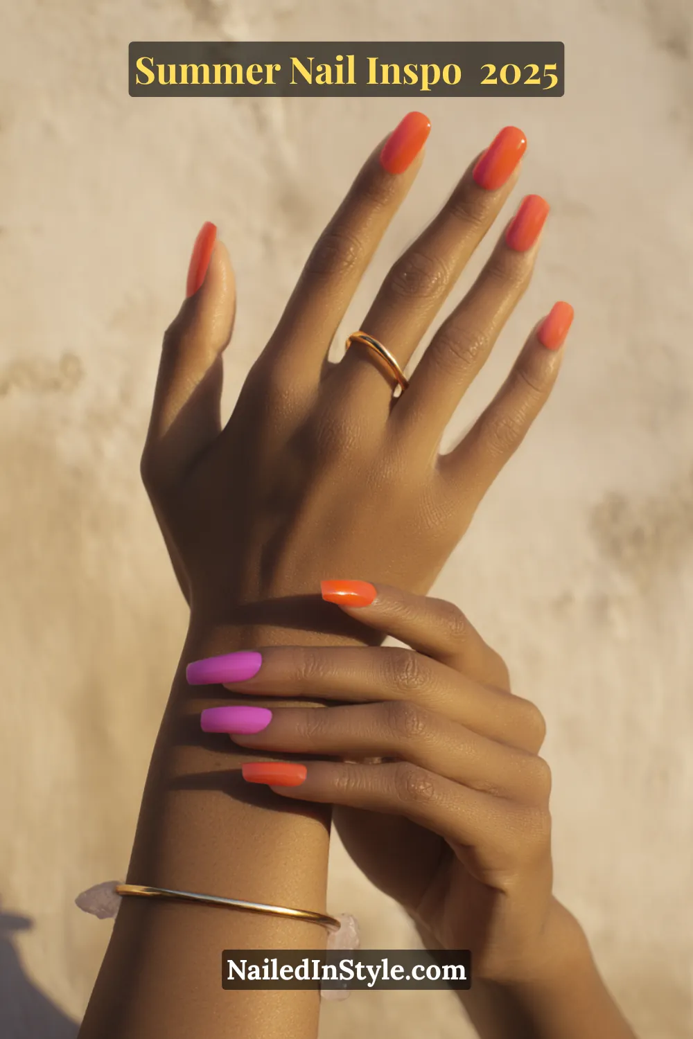 Close-up of long square nails painted in alternating fiery orange and bold magenta shades with a glossy finish.