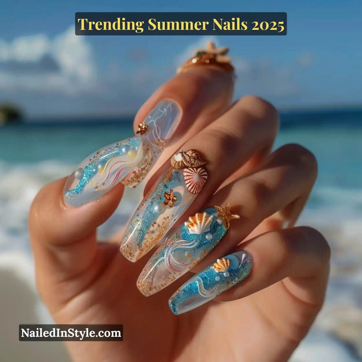 Long clear nails with 3D seashells, pearls, and glittery ocean waves, shot on the beach with ocean waves in the background.