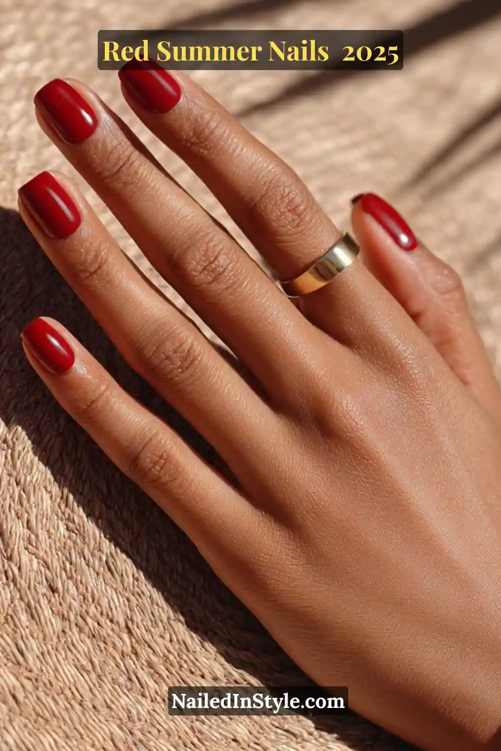 Red Summer Nails 2026: Bold, Fiery & Classic Warm-Weather Looks 7 Well-groomed hand with cherry red short square nails and a gold band on brown skin, summer light