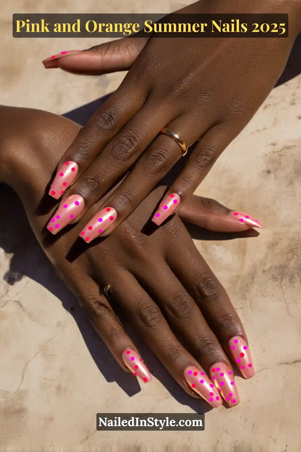 Pink and Orange Summer Nails 2026: Sunset Tips, Endless Vibes 13 Hands with long square-shaped nails in a chrome orange base with scattered hot pink dots, posed side by side on deep skin against a stone surface.