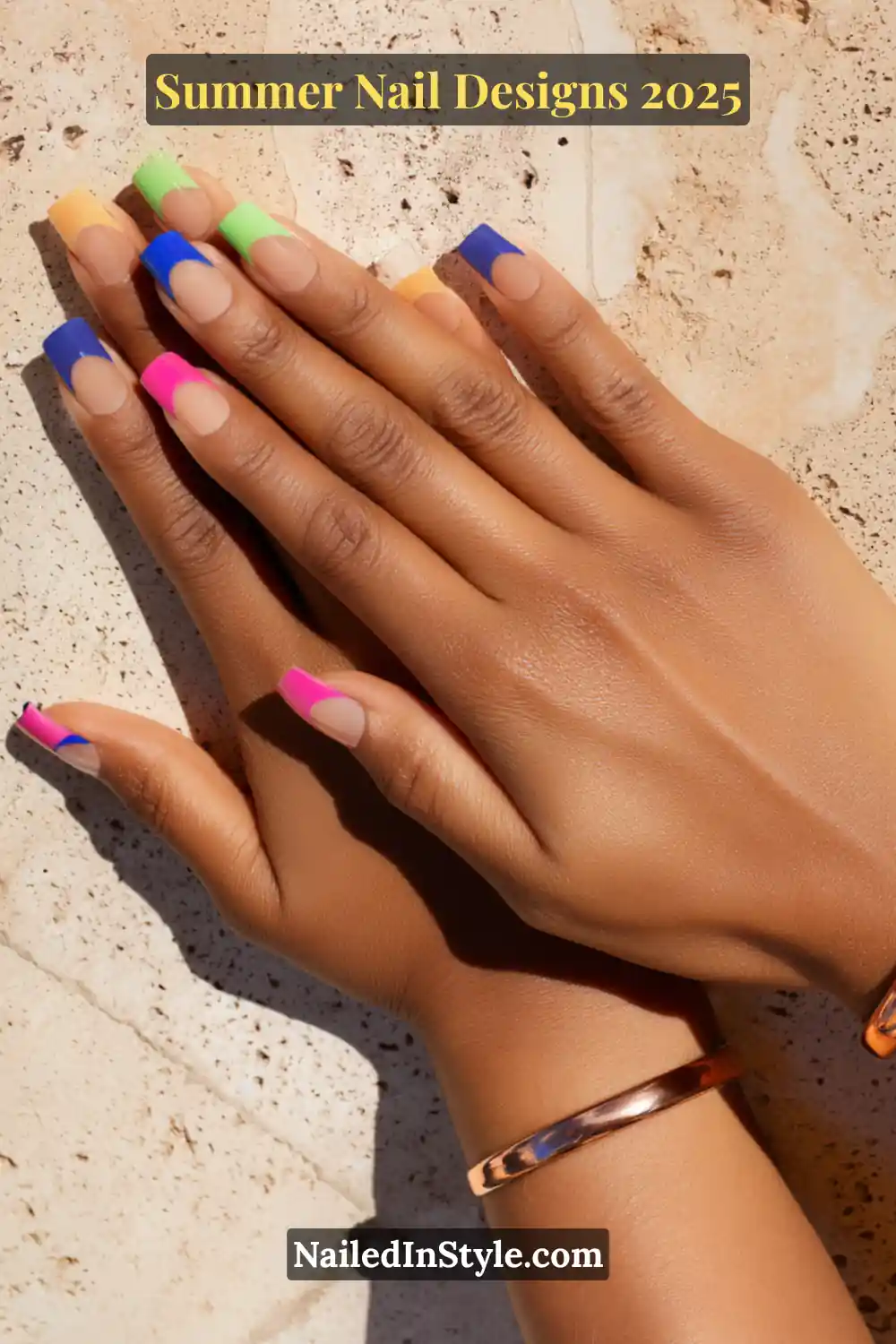 Hands with multicolor French tip nails featuring vibrant blocks of blue, pink, green, yellow, and orange on a natural skin-tone base