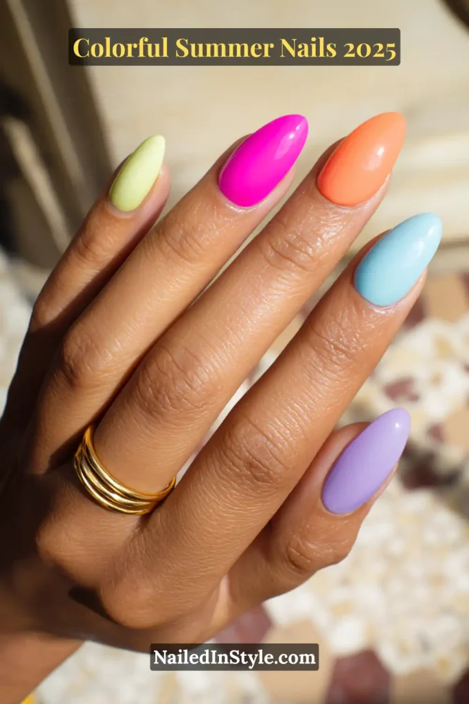 Colorful Summer Nails Hand with medium brown skin tone showing almond-shaped nails painted in pastel yellow, neon pink, tangerine orange, baby blue, and lavender