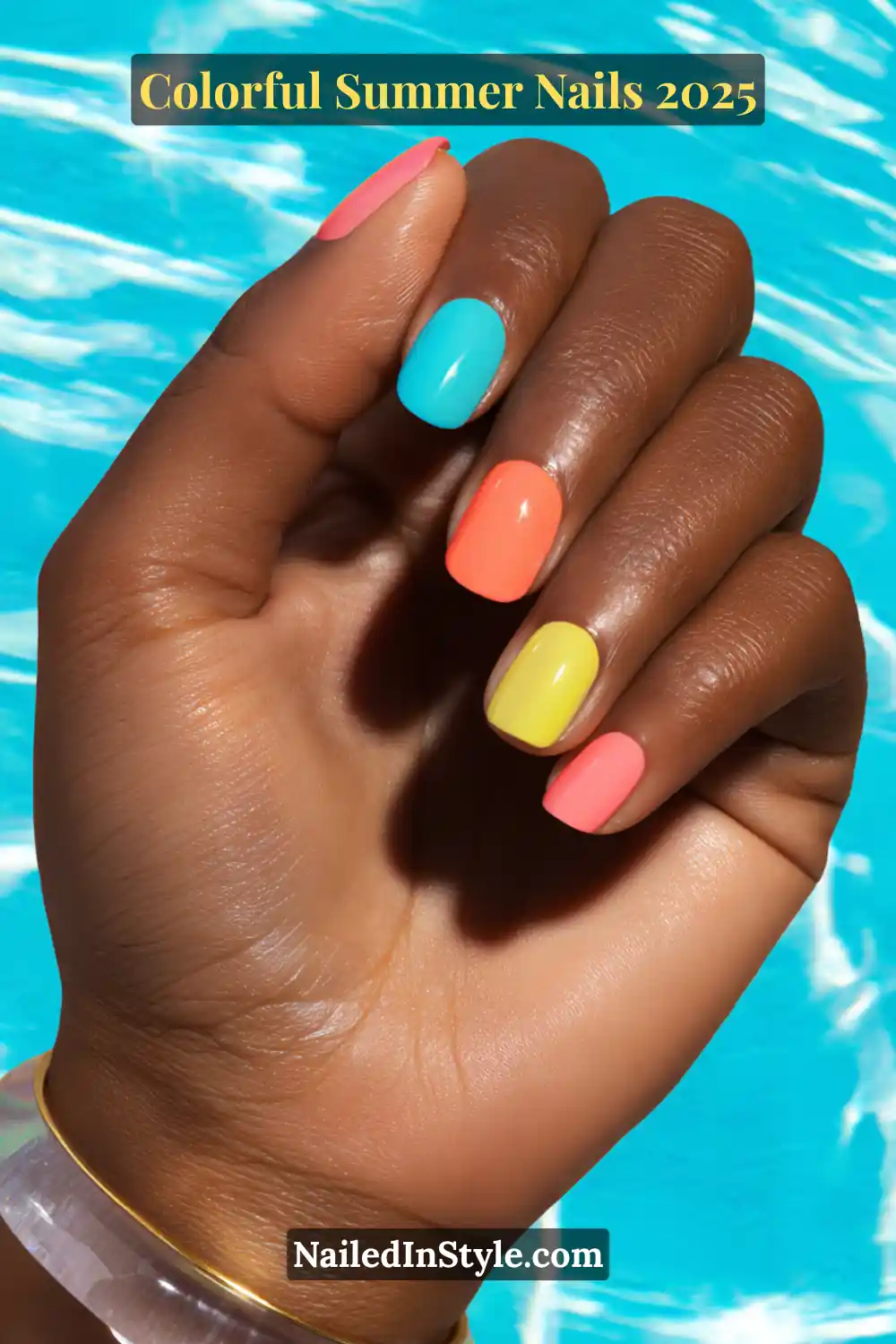Colorful Summer Nails 2026: Bold, Fun & Bright Manicure Ideas 3 Hand with deep brown skin tone showing short square nails painted in turquoise blue, coral pink, lemon yellow, and orange, held against a bright pool background