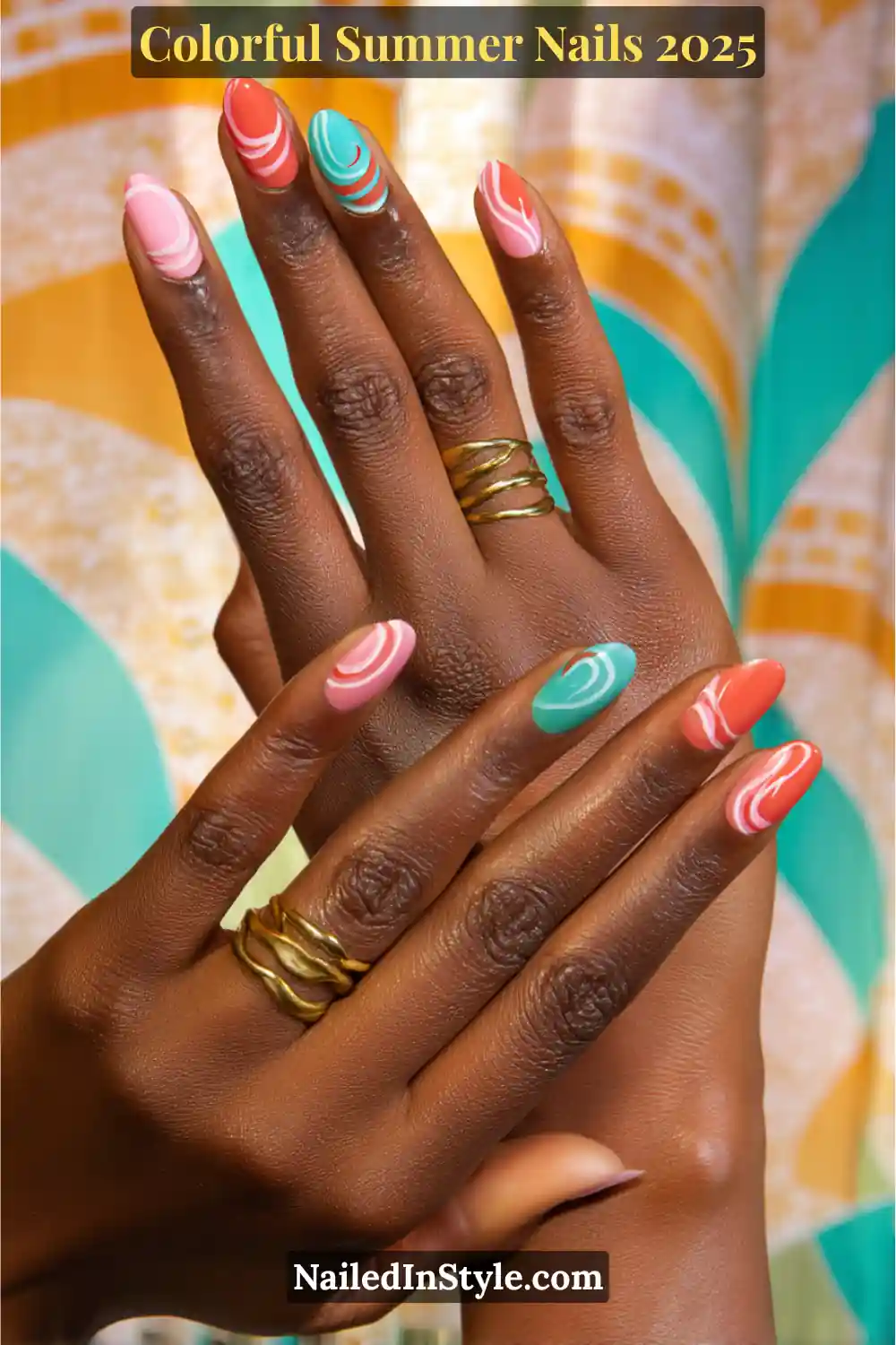 Colorful Summer Nails 2026: Bold, Fun & Bright Manicure Ideas 4 Two hands with rich brown skin tone showing almond-shaped nails in tangerine, teal, and bubblegum pink with swirling white retro patterns