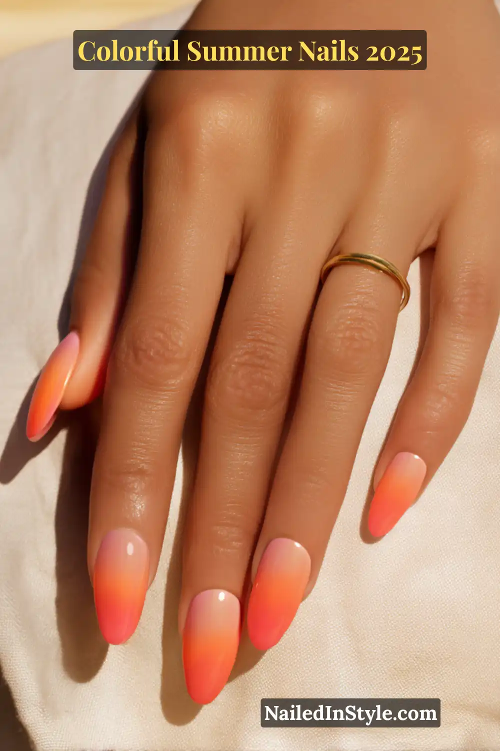 Colorful Summer Nails 2026: Bold, Fun & Bright Manicure Ideas 7 Hand with light tan skin tone showing almond-shaped nails in a smooth pink to orange ombré gradient resembling a summer sunset