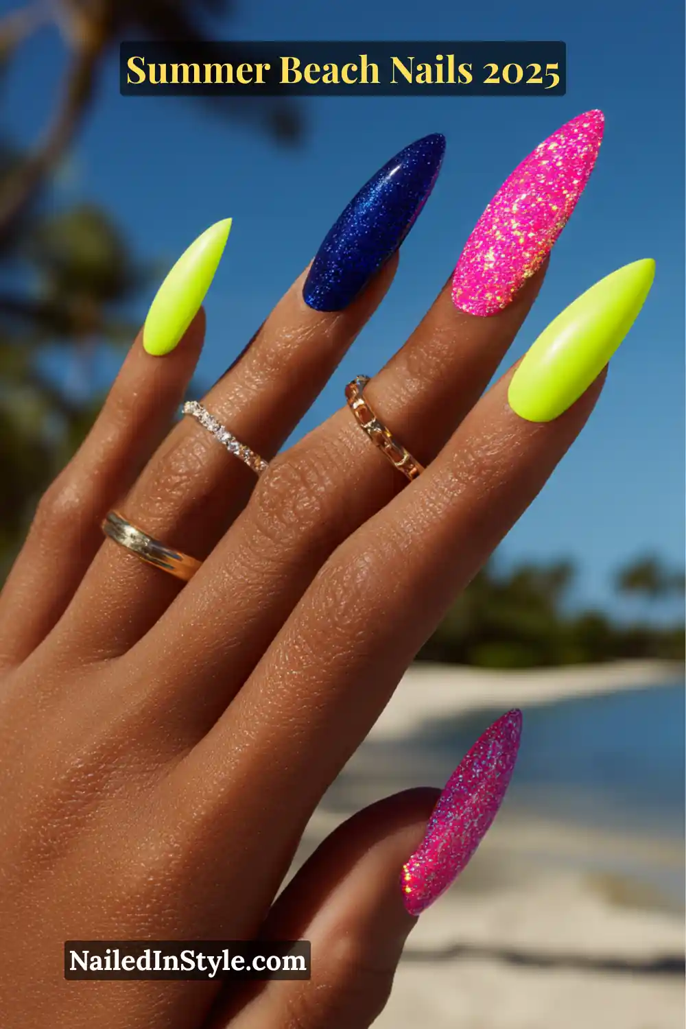 Summer Beach Nails 2026: Tropical, Trendy & Totally You 11 Deep skin tone hand with long stiletto nails in neon yellow, cobalt chrome, and glittery magenta polish