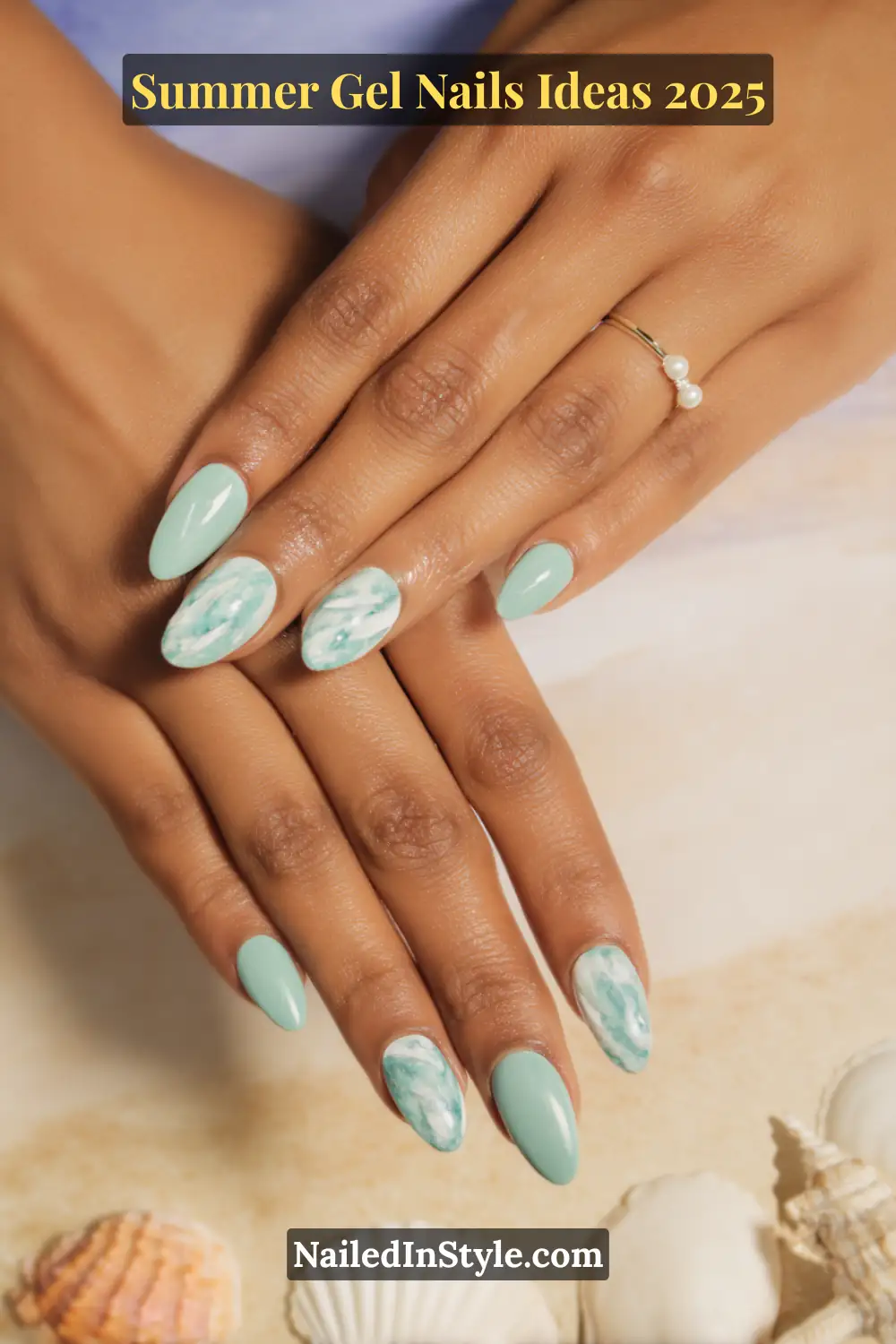 Summer Gel Nails Ideas 2026 3 Close-up of golden tan hands with almond-shaped gel nails painted in seafoam green, featuring marble accent nails in white and aqua blue, styled against a soft beach background with seashells.