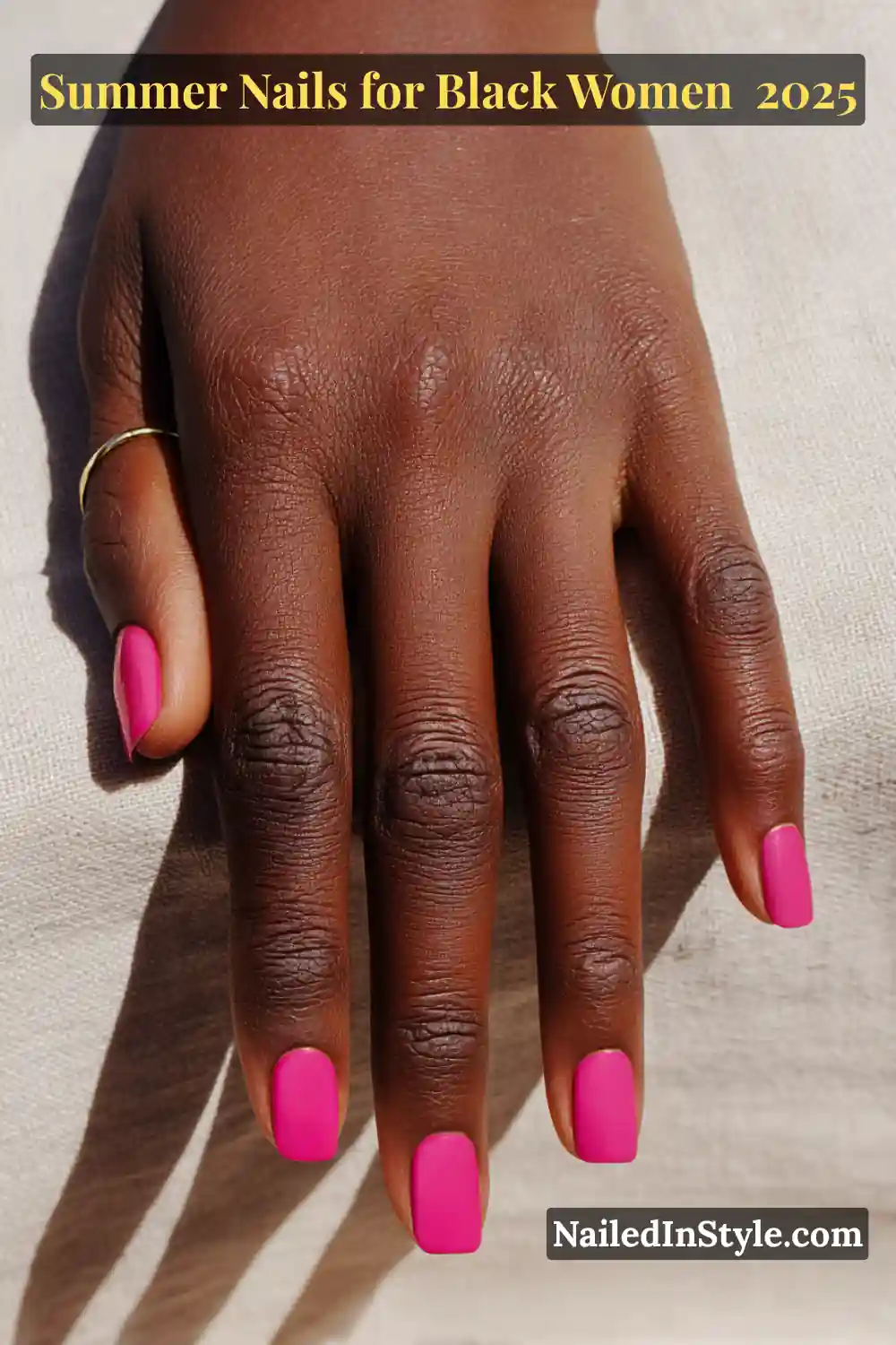 Close-up of Black woman’s hand with short square-shaped hot pink nails, summer 2025 nail design