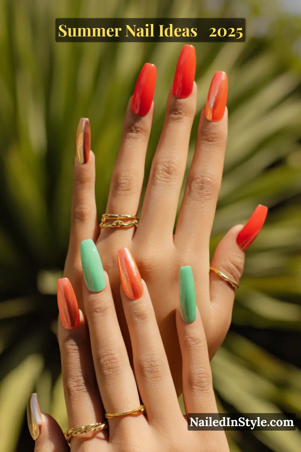 Hands with long coffin-shaped nails featuring coral red, seafoam green, and gold chrome polish, against a palm-leaf background.