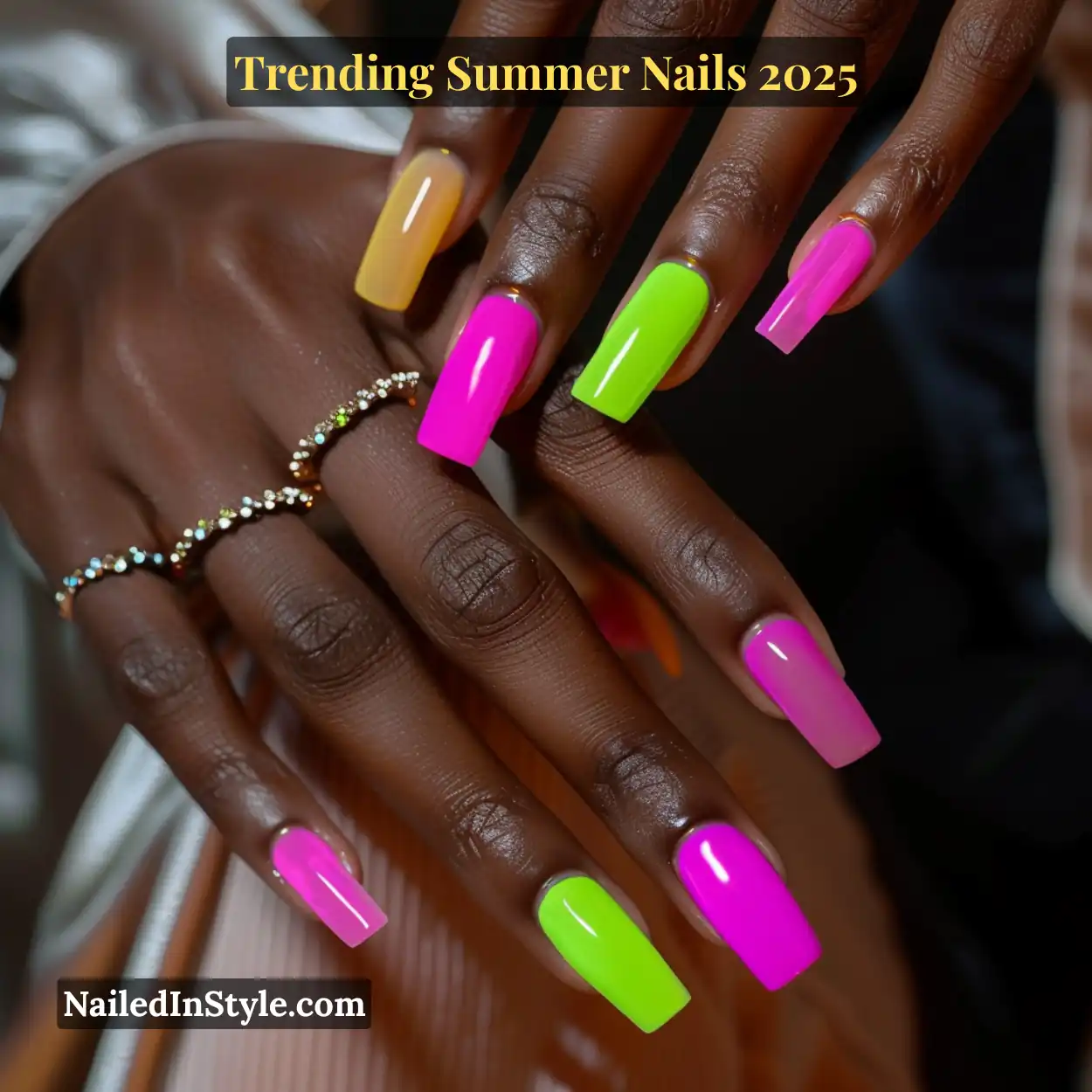 Bold neon square nails in hot pink, lime green, and sunny yellow on a deep skin tone, styled with gold gemstone rings.
