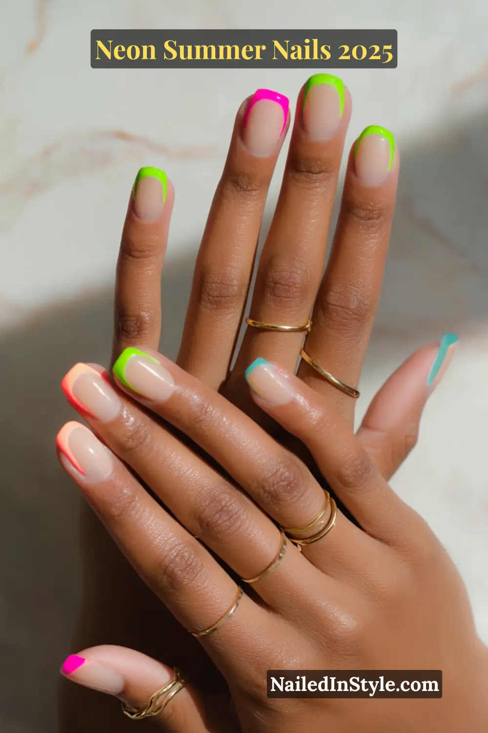 Neon Summer Nails 2026: Bright, Bold & Sun-Soaked Perfection 12 Two hands with natural nude nails featuring a reverse French manicure design with neon cuticle accents in green, pink, orange, and blue.