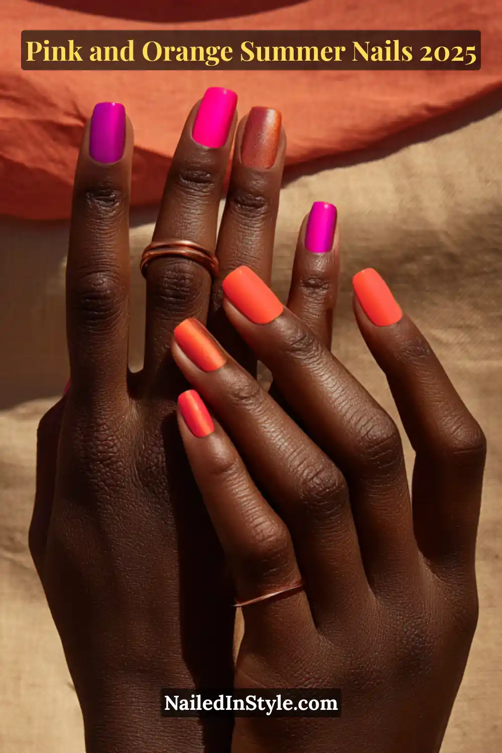 Pink and Orange Summer Nails 2026: Sunset Tips, Endless Vibes 5 Hands with short square-shaped nails in glossy neon pink, chrome orange, and matte tangerine tones, posed palm-over-palm on deep skin against warm fabric.