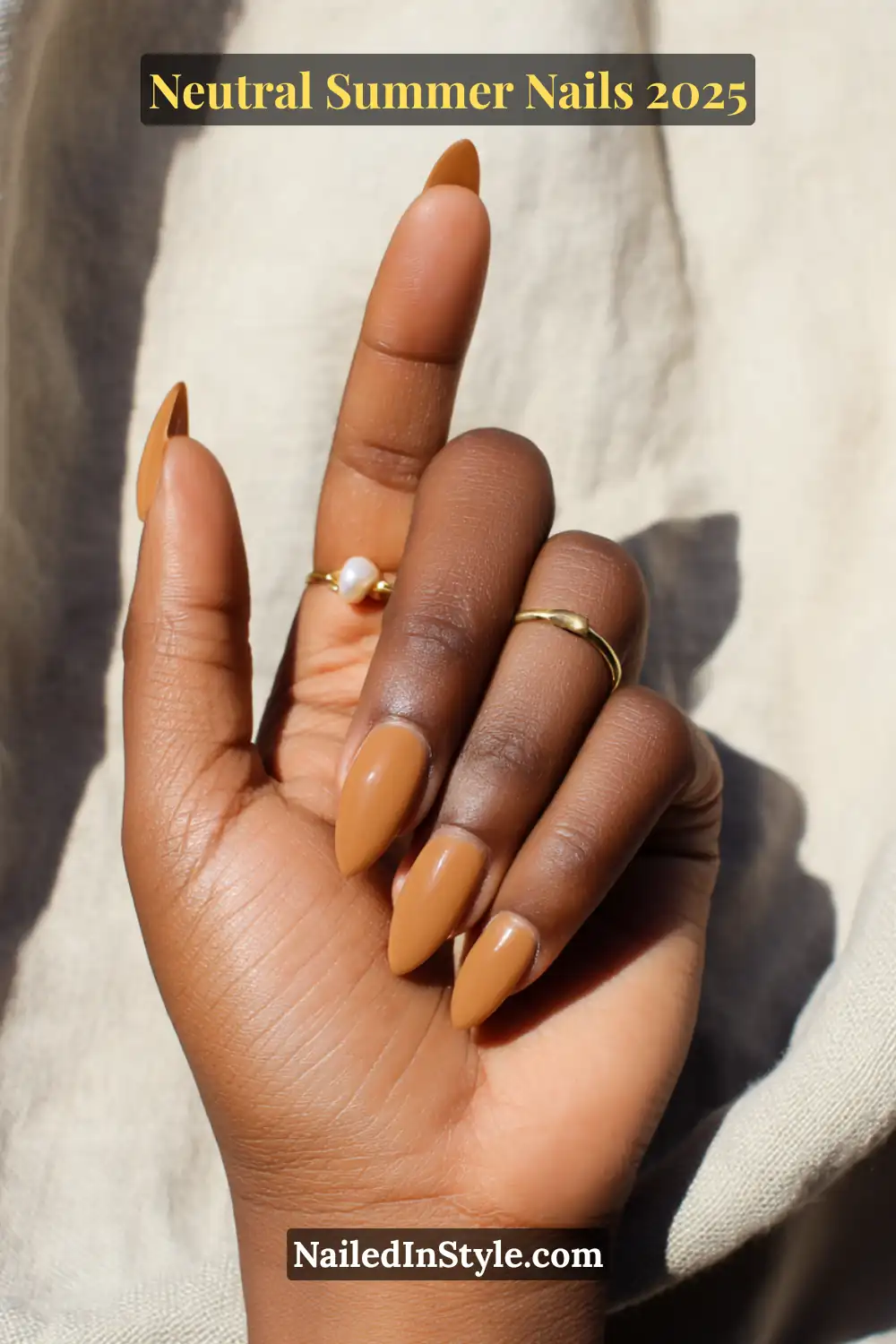 Neutral Summer Nails 2026: Clean, Chic & Warm-Weather Ready 13 Deep skin tone with almond-shaped nails in a rich caramel gel polish, styled with minimalist gold and pearl rings.