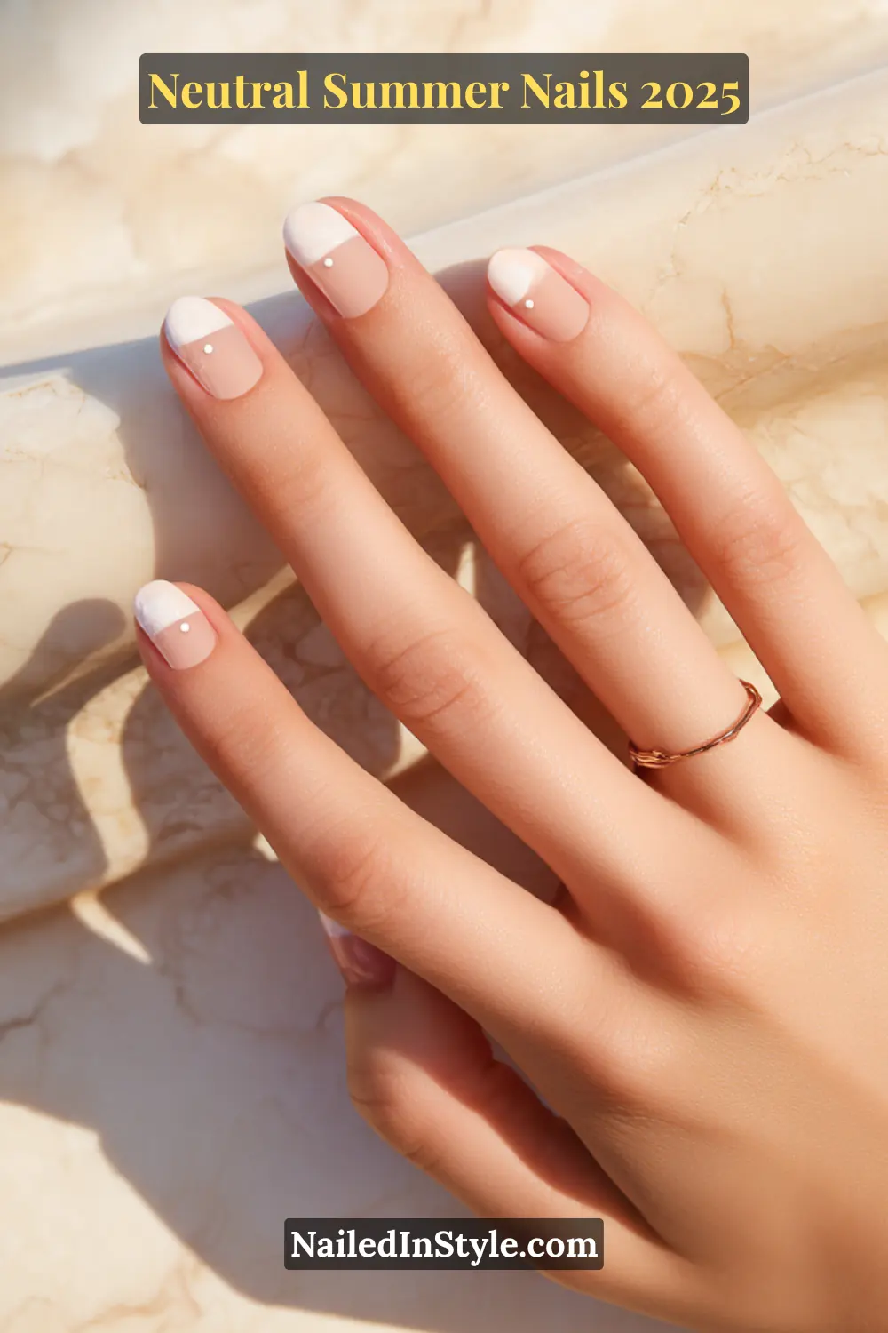 Neutral Summer Nails 2026: Clean, Chic & Warm-Weather Ready 21 Close-up of fair-toned hand with short square nude nails featuring white half-moon tips and minimalist dot nail art.