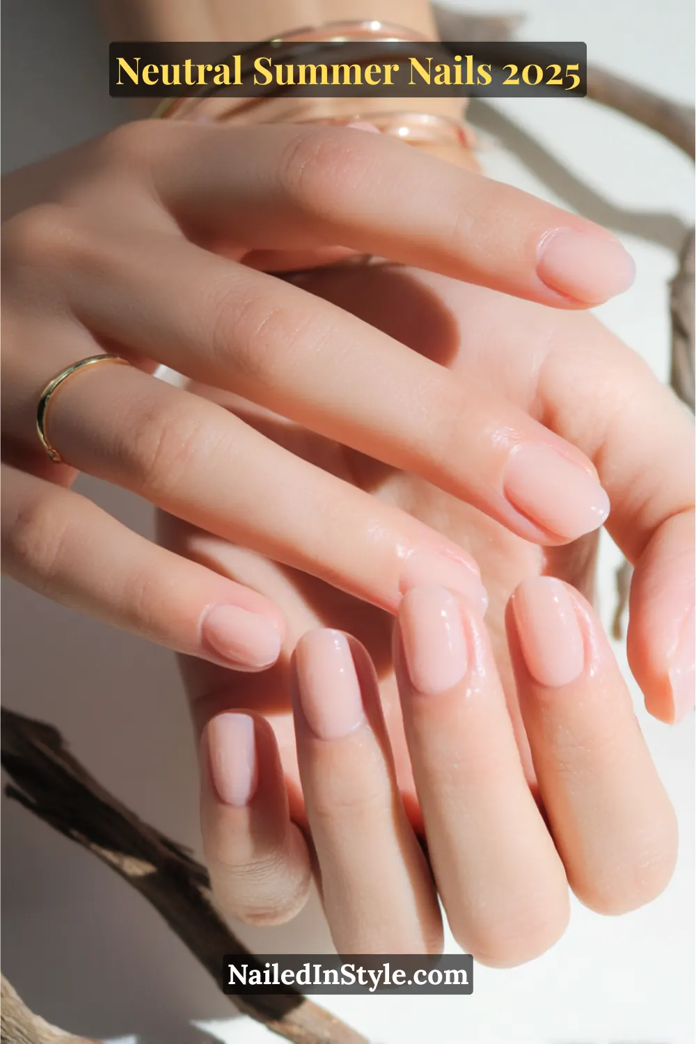 Neutral Summer Nails 2026: Clean, Chic & Warm-Weather Ready 14 Close-up of fair-toned hands with short squoval nails painted in a sheer peach polish and high-gloss finish, styled with gold rings.