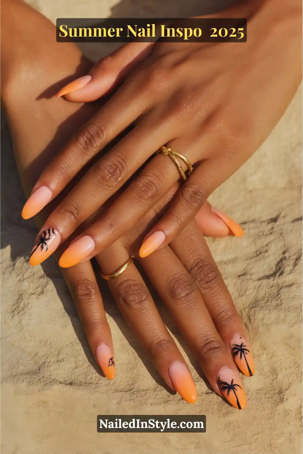 Close-up of hands with almond-shaped nails featuring orange to nude ombré fade and black palm tree silhouette nail art.