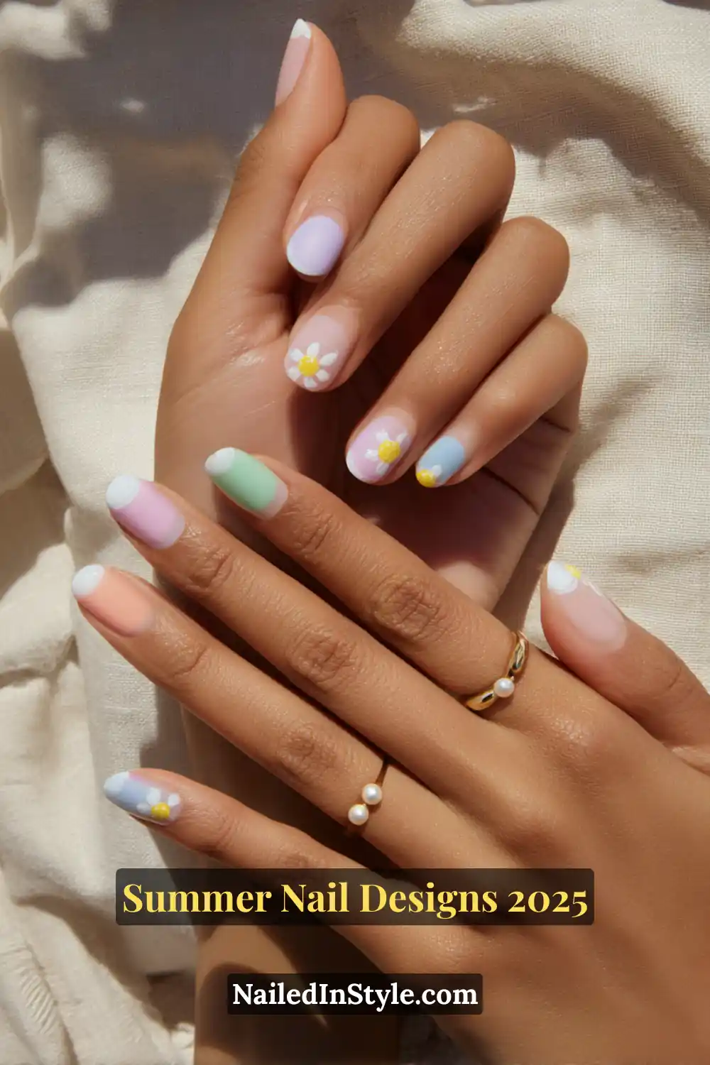 Hands with pastel French tips and white daisy nail art on short round nails