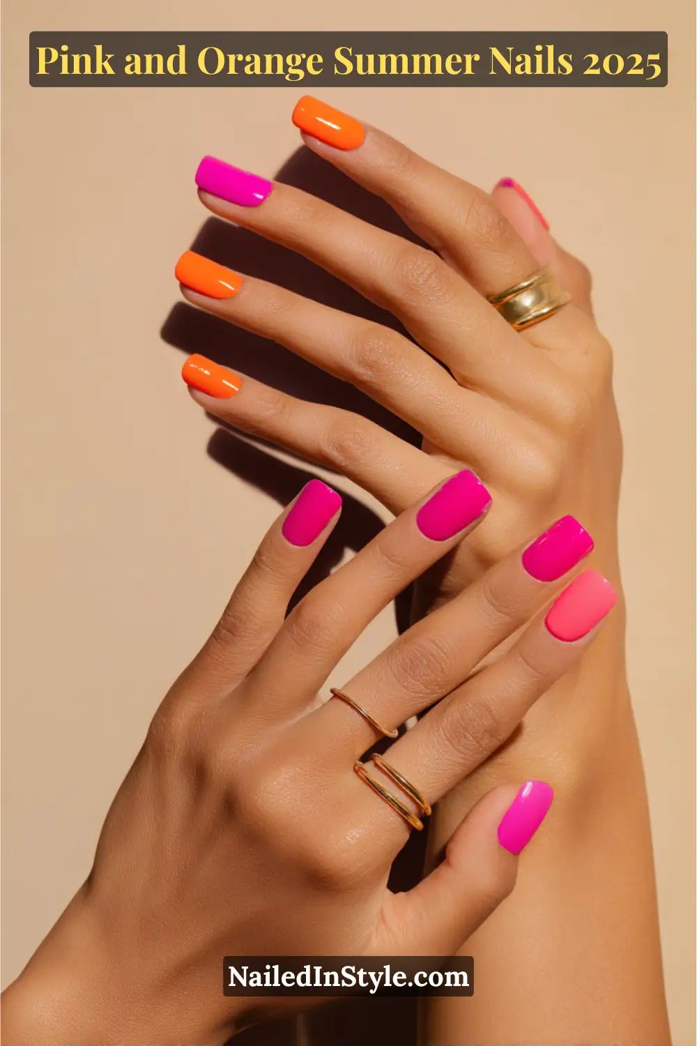 Pink and Orange Summer Nails 2026: Sunset Tips, Endless Vibes 11 Hands with medium-length square nails painted in alternating neon pink and orange halves, posed in a soft clasp against a warm beige background with gold rings.