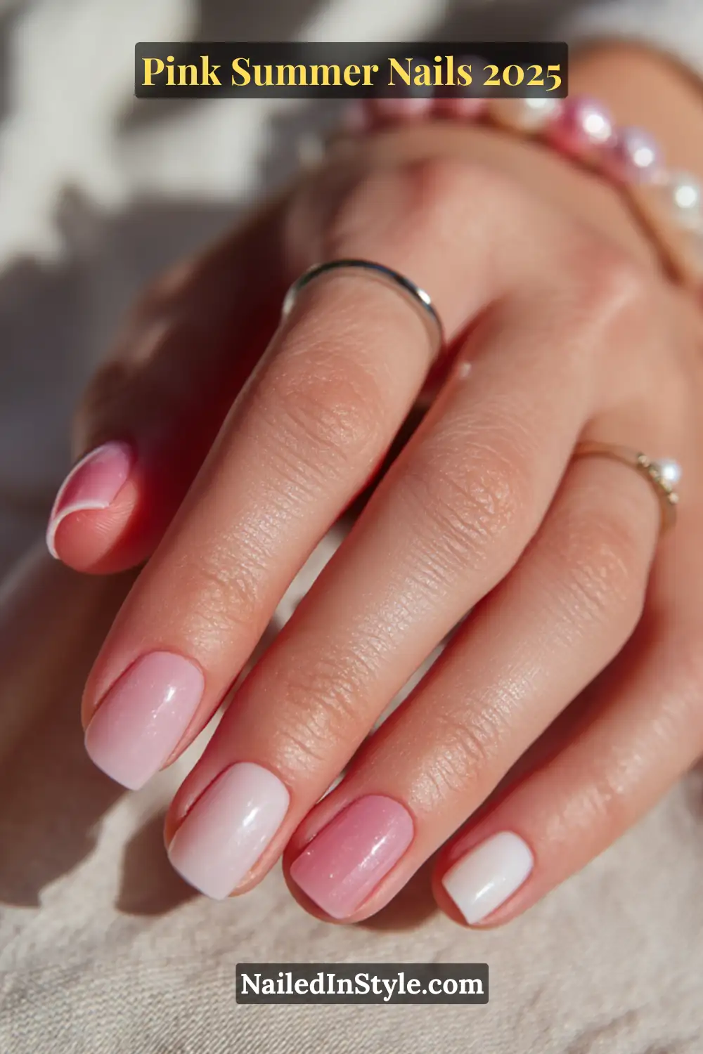 Close-up of fair skin hand with short pink nails in pastel tones, featuring baby pink, ballet blush, and sheer rose