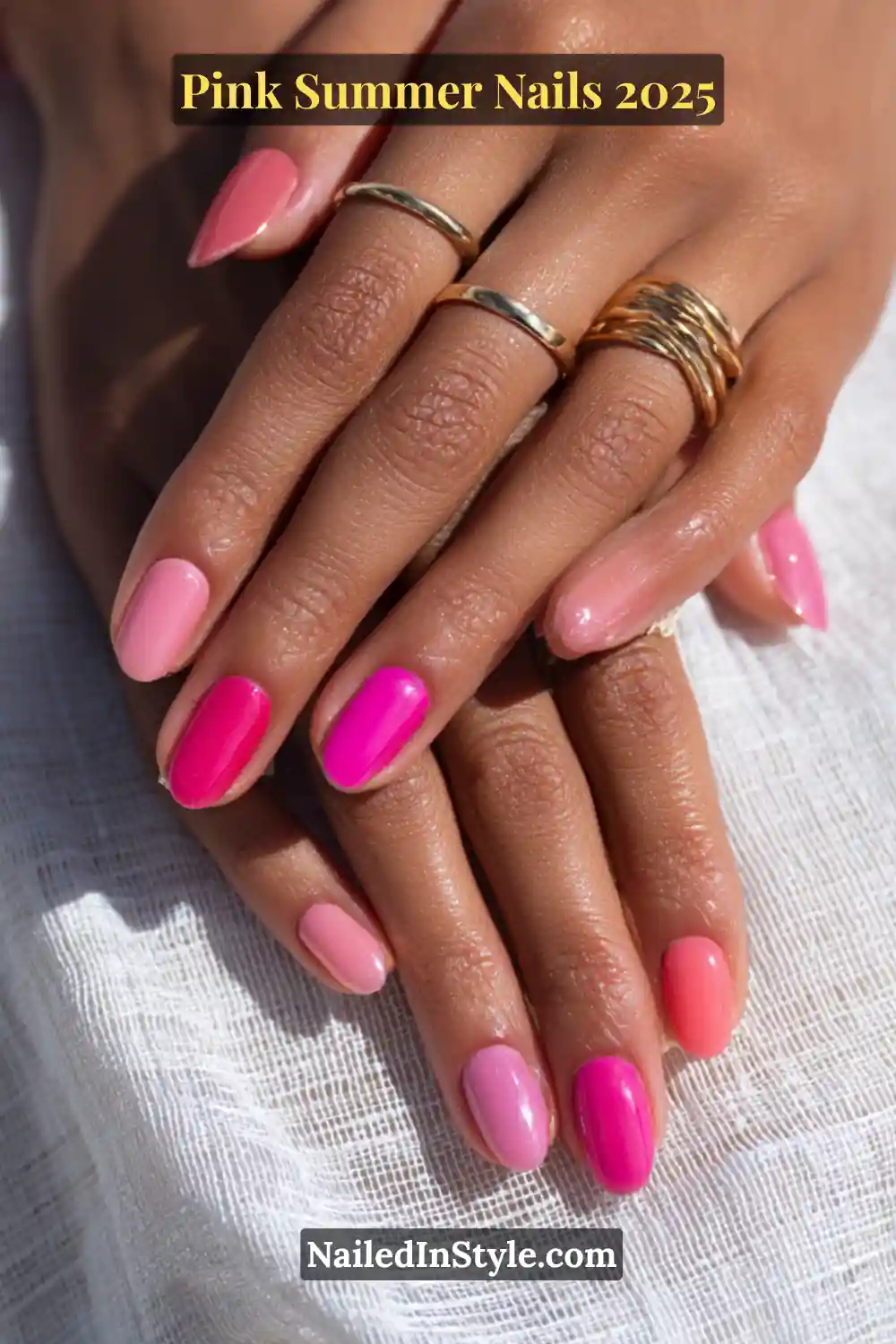 Close-up of medium skin hand with glossy pink nails in peony pink, watermelon, and pink coral tones