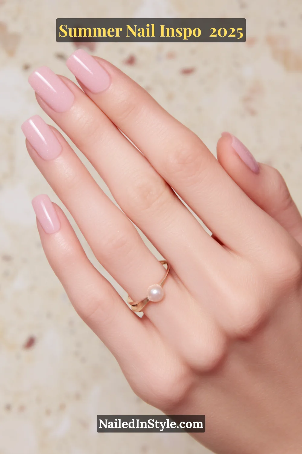 Close-up of a hand with medium-length square nails in a sheer pink jelly polish with fine shimmer, paired with a gold pearl ring.