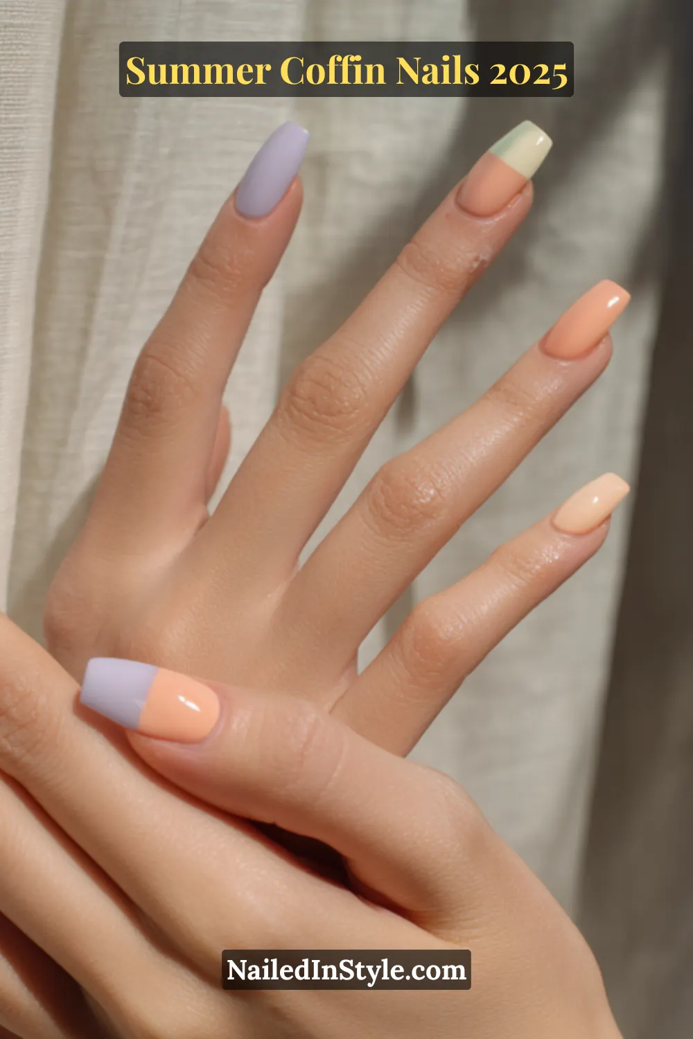 Light skin hand with peach, pistachio, and light lavender coffin nails, including modern color-blocked designs, against a neutral fabric background.