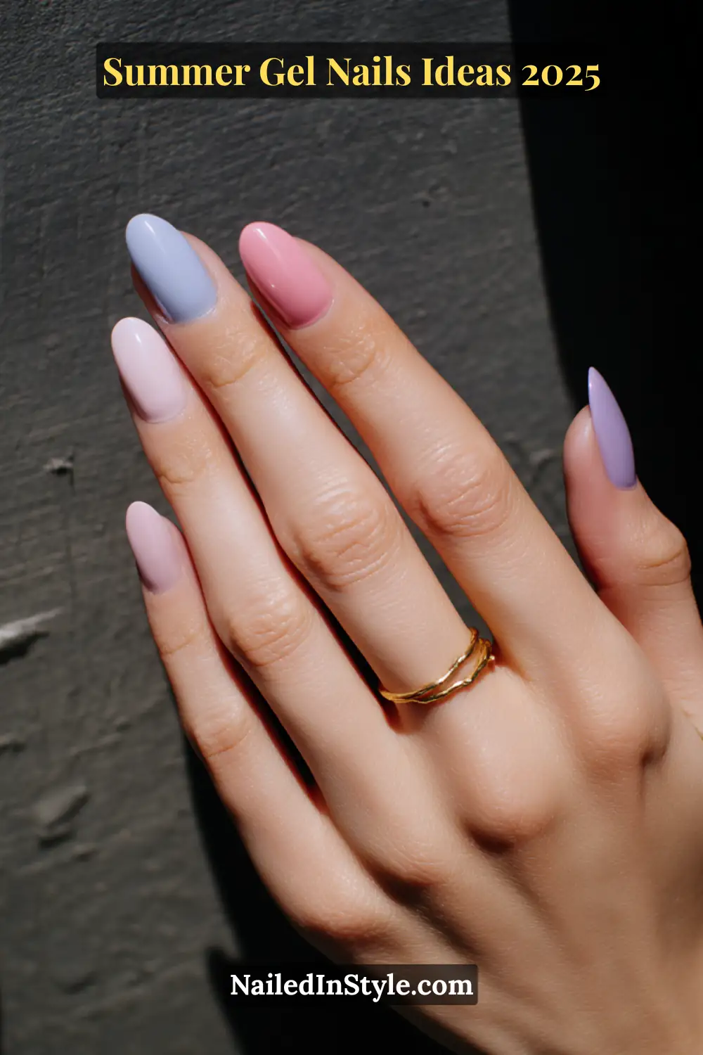 Summer Gel Nails Ideas 2026 6 Close-up of a fair-skinned hand with almond-shaped gel nails in pastel shades: lilac frost, rose quartz, cotton candy pink, and baby lavender, styled with a dainty gold twisted ring.