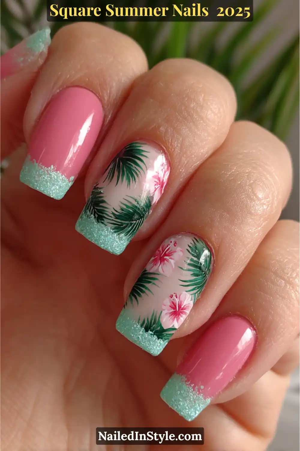 Short square nails painted in glossy pink with aqua glitter tips and tropical floral nail art