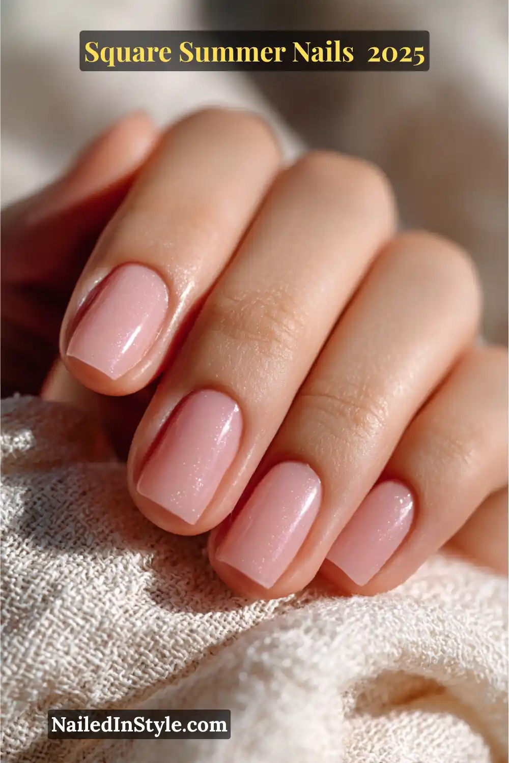 Close-up of a hand with short square nails painted in a delicate blush pink polish with subtle shimmer — elegant and fresh for summer