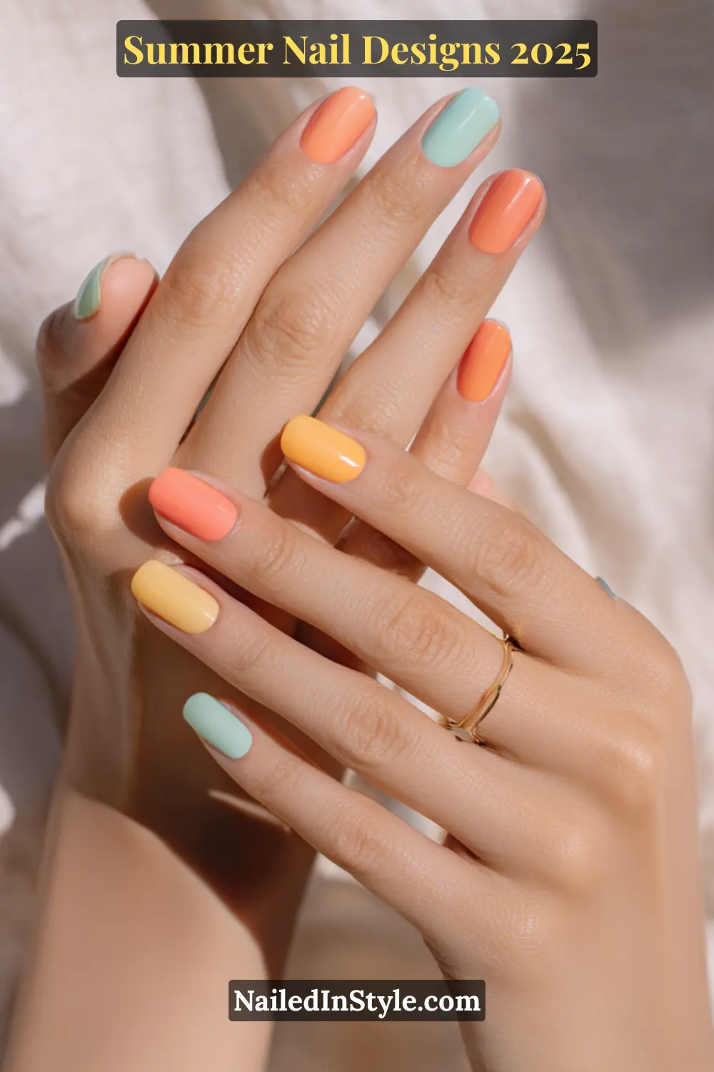 Light-toned hands with summer nail polish in coral, mint green, and warm yellow for a fresh seasonal look