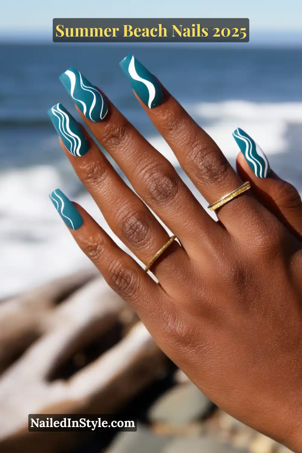 Summer Beach Nails 2026: Tropical, Trendy & Totally You 20 Hand with deep teal square nails featuring flowing white wave lines, beach background