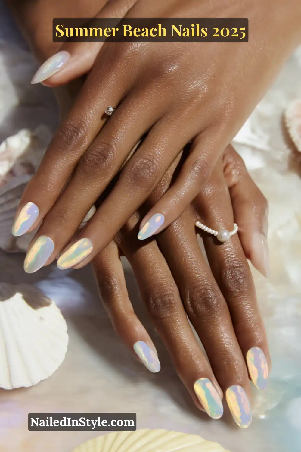 Summer Beach Nails 2026: Tropical, Trendy & Totally You 12 Close-up of two hands with iridescent shell-inspired nails in lavender and aqua on deep skin tone