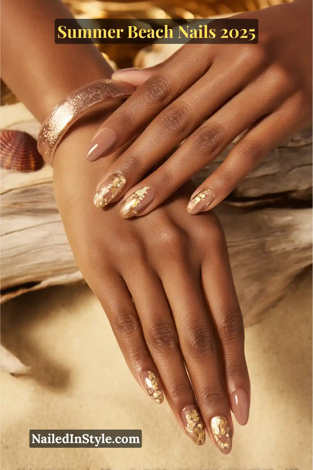 Summer Beach Nails 2026: Tropical, Trendy & Totally You 16 Close-up of two hands with mocha-toned nails featuring gold foil accents on a sandy beach backdrop
