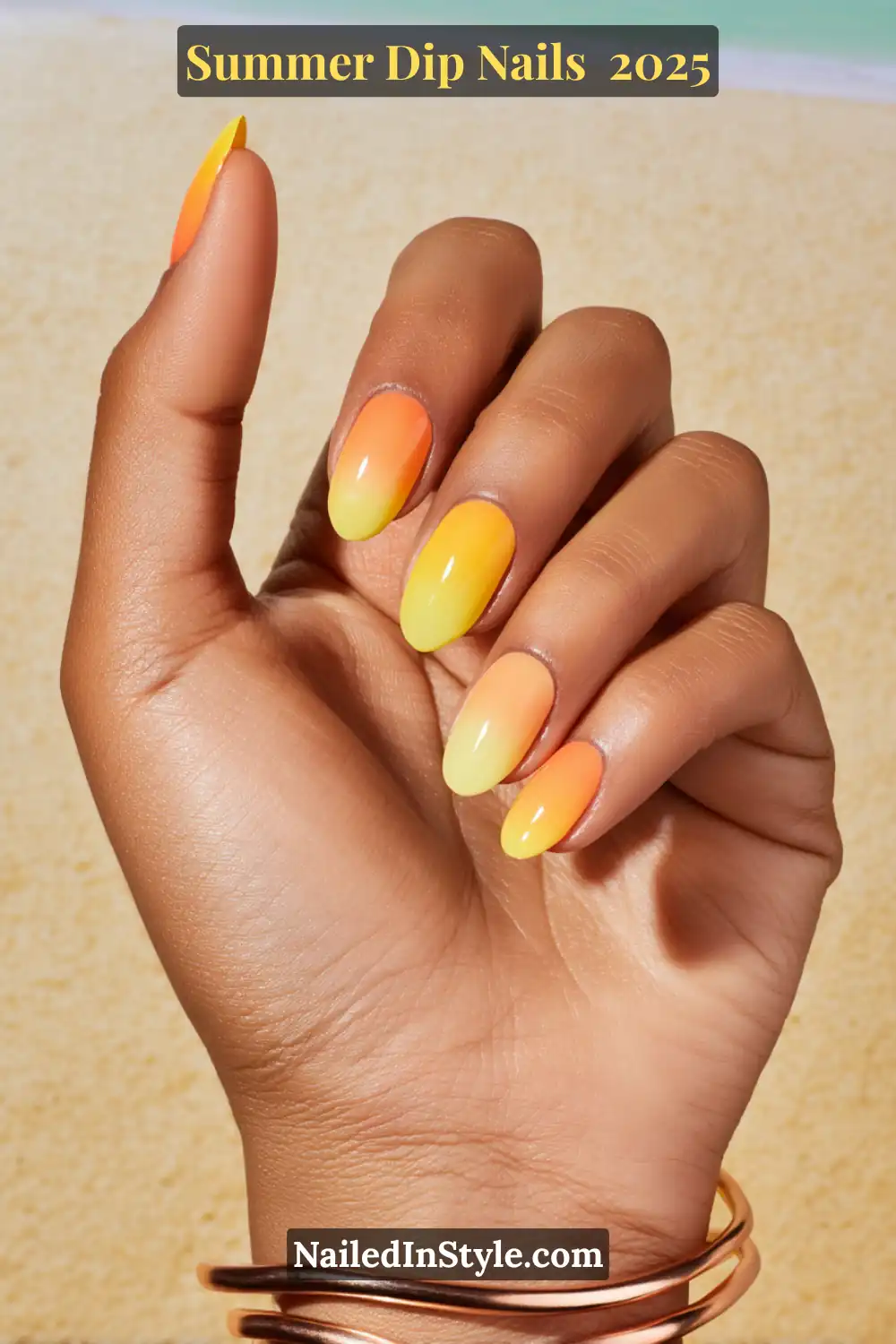 Close-up of a hand with oval-shaped dip nails in a smooth yellow-to-orange ombré gradient, set against a sunny beach backdrop.
