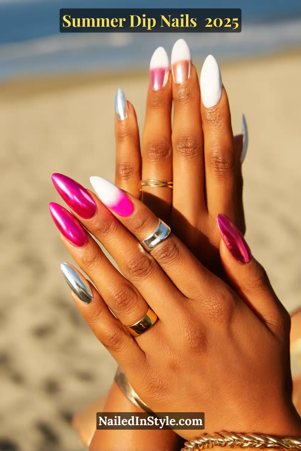 A pair of hands with almond-shaped dip nails in white, silver chrome, neon pink, and ombré accents against a beach backdrop.