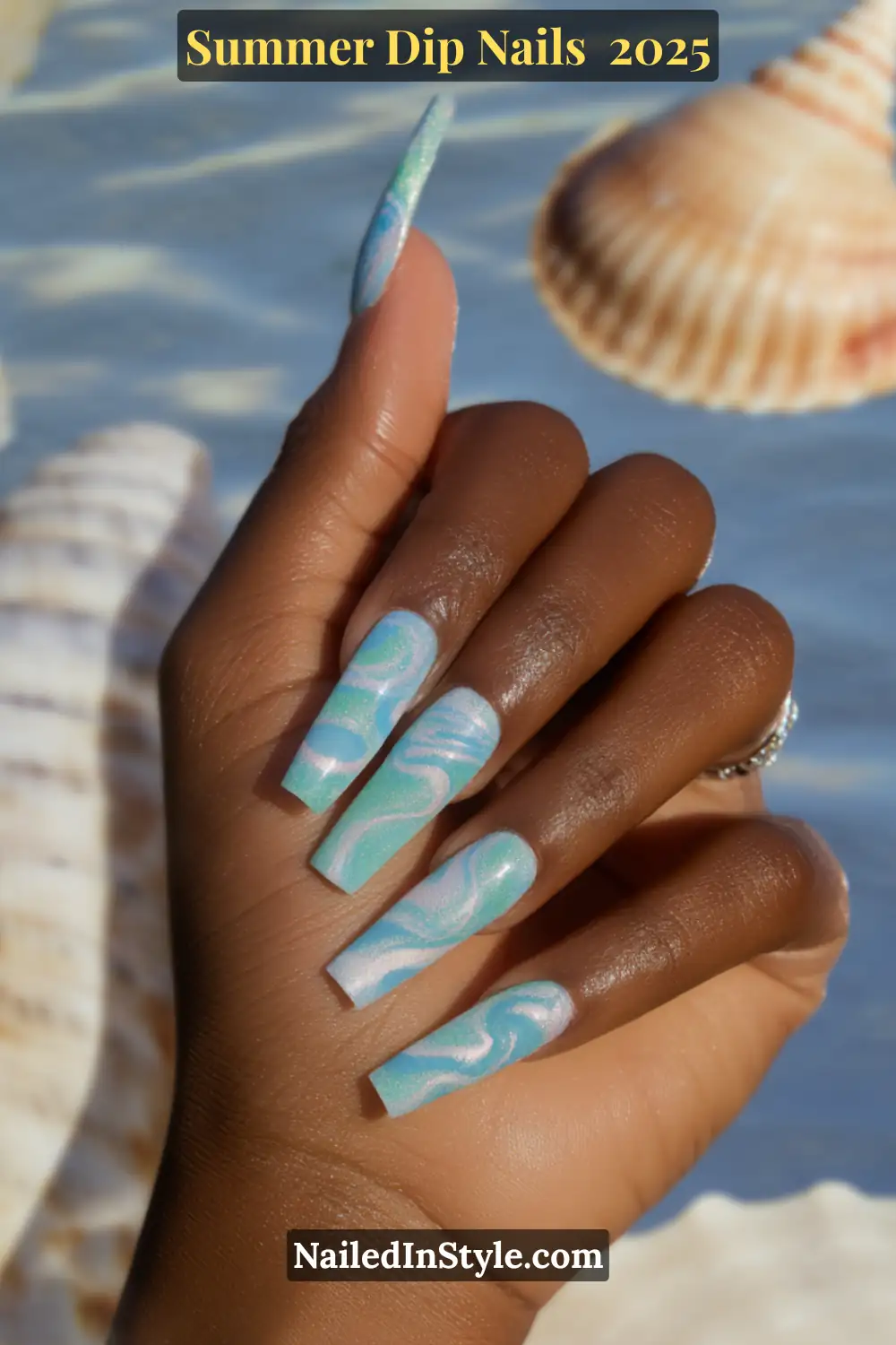 Close-up of long coffin-shaped nails with swirling aqua-blue and white marble dip design, inspired by ocean waves.