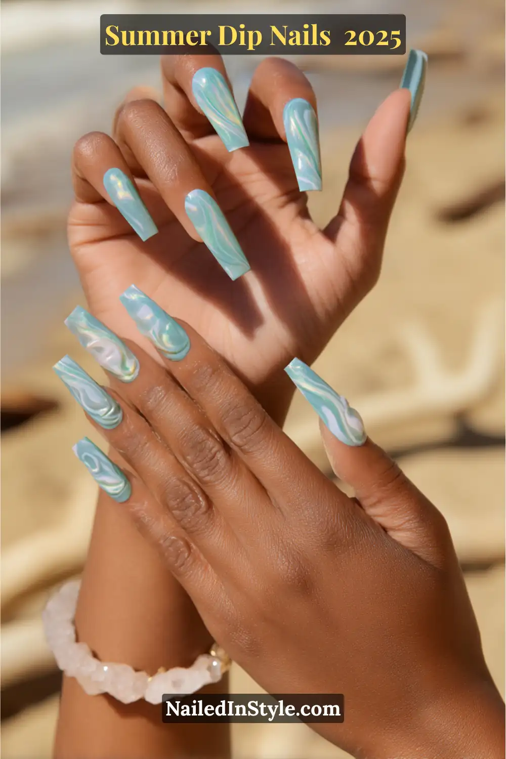 Long coffin-shaped nails with a blue and seafoam green marble swirl dip design, shimmering in the sunlight.