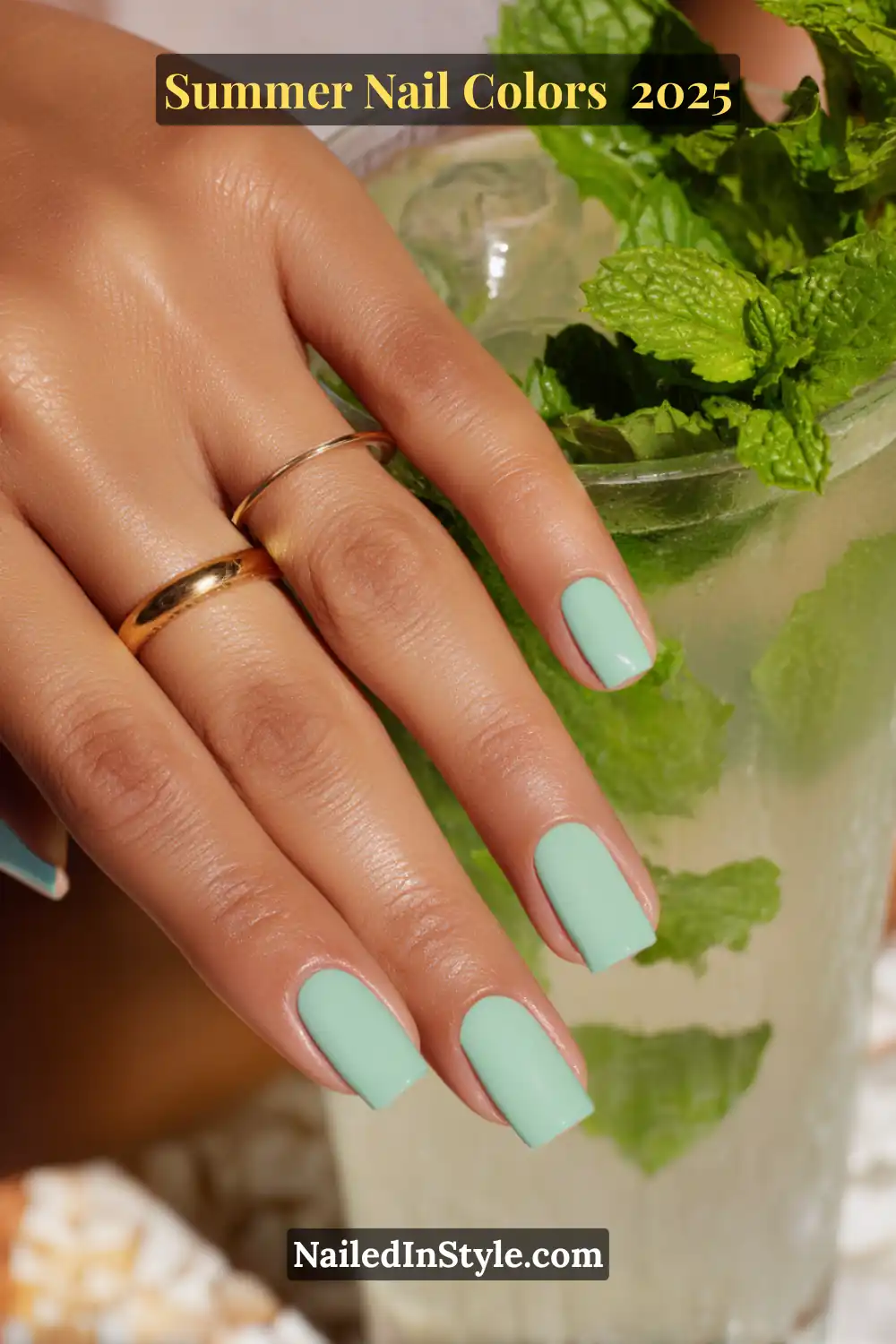 Hottest Summer Nail Colors 2026: Bold, Breezy & On-Trend 15 Hand with square-shaped mint green nails holding a chilled mojito garnished with fresh mint leaves.