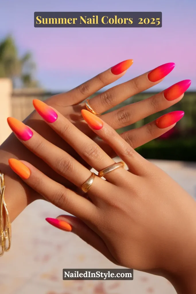 Hands with long almond-shaped nails painted in a vivid ombré of orange and pink, glowing under a summer sunset.