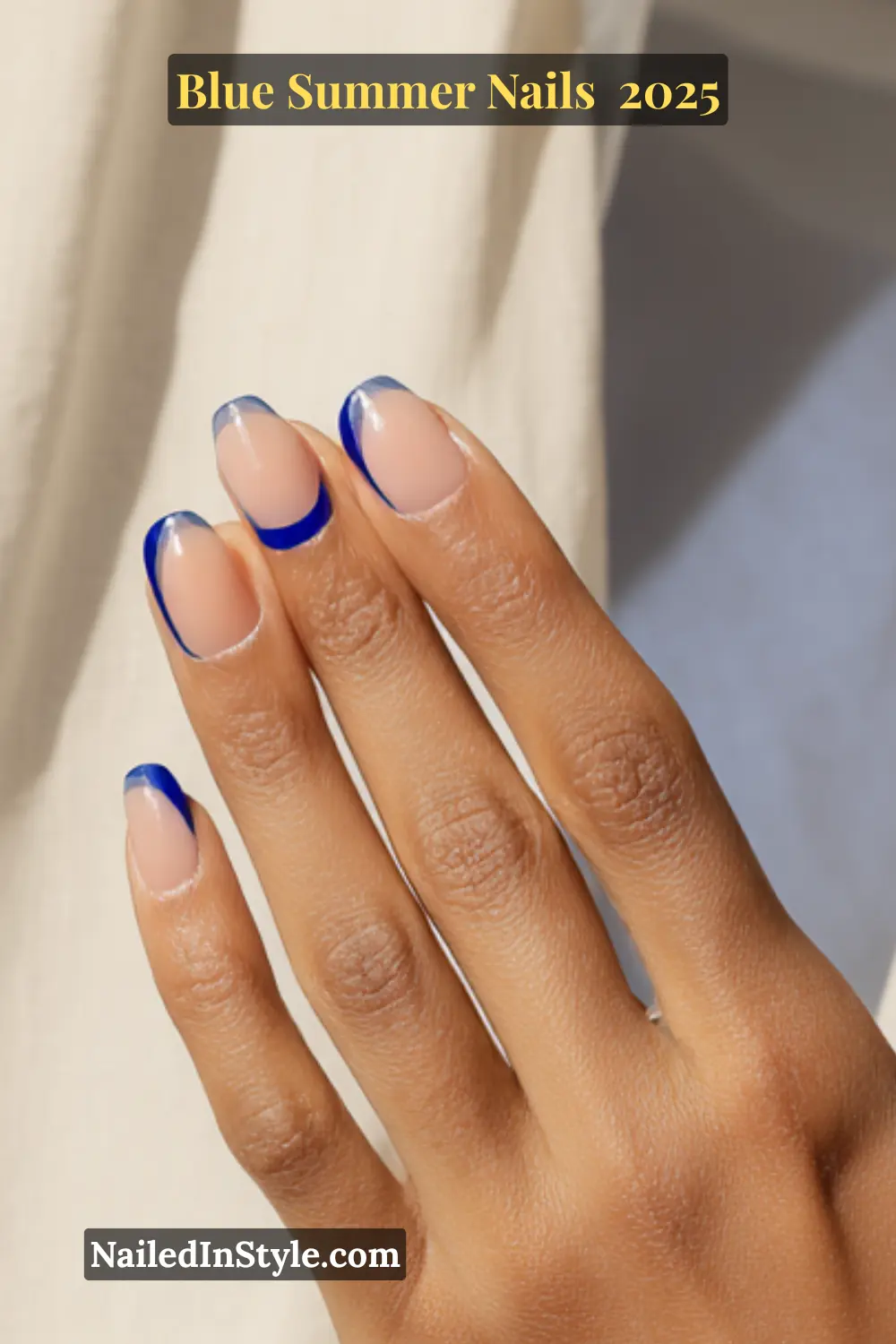 Blue Summer Nails 2025: Make a Splash with the Coolest Trends of the Season 21 Blue Summer Nails Close-up of a hand with glossy royal blue reverse French tip nails on a nude base, styled for summer 2025.