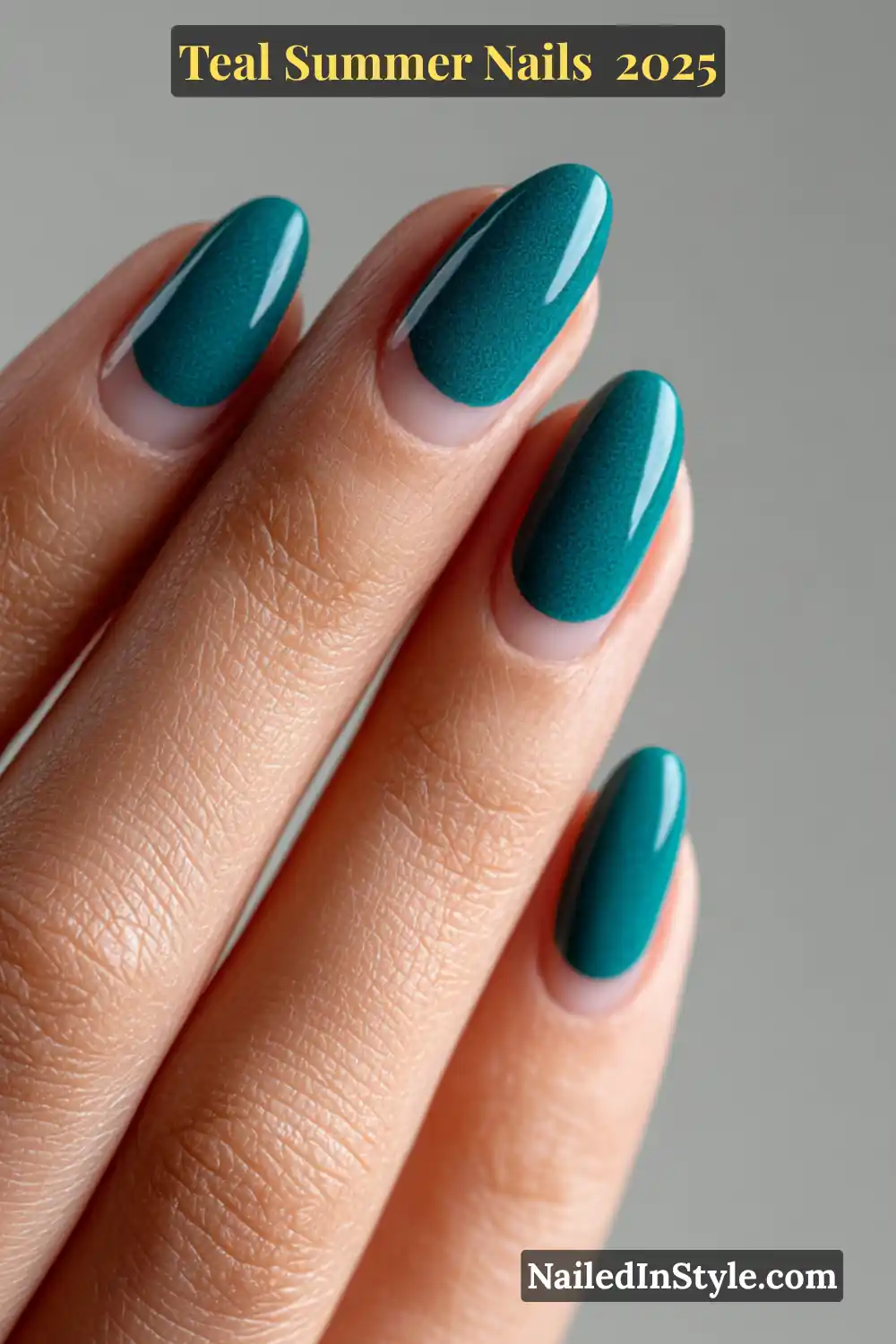 Close-up of almond-shaped teal nails with a glossy reverse French design over a nude base on a fair-toned hand