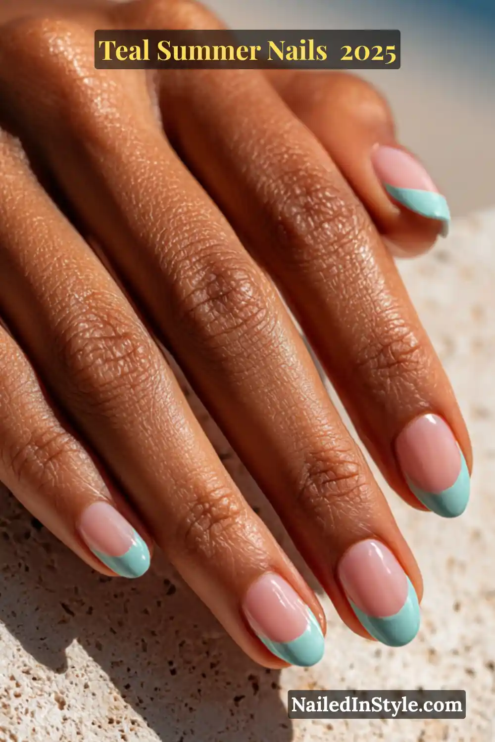 Natural hand with deep-toned skin showcasing soft mint green French tip nails on a sheer nude base, taken in bright natural sunlight
