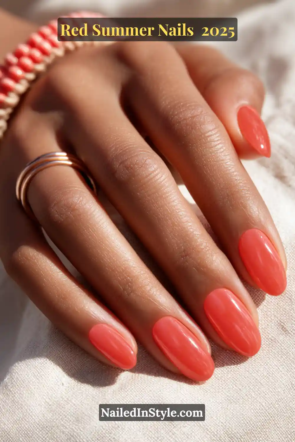 Red Summer Nails 2026: Bold, Fiery & Classic Warm-Weather Looks 14 Glossy watermelon pink jelly nails on medium brown skin with rose gold rings and beaded bracelet