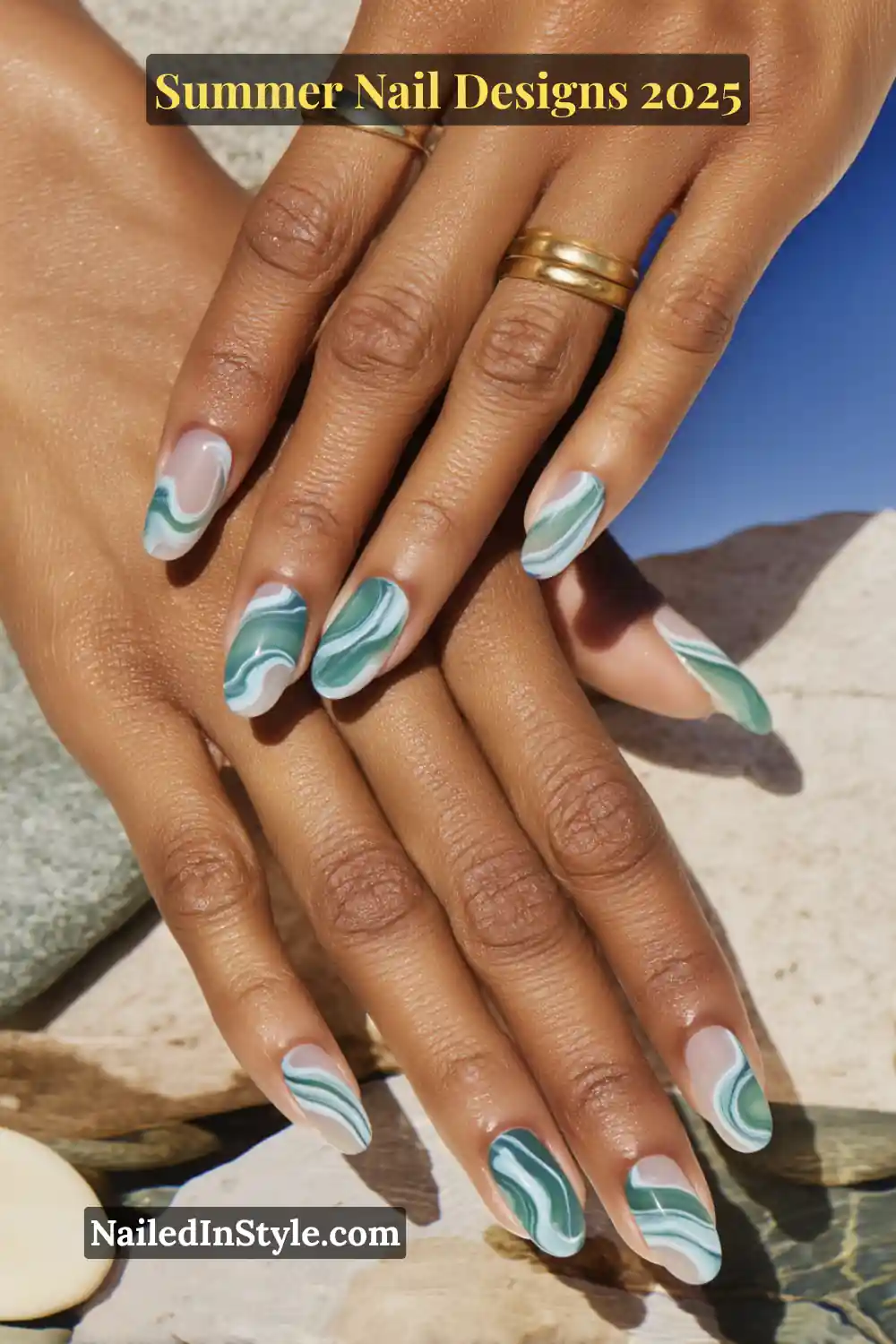 Hands with marble nail art in seafoam green, teal, and white swirls
