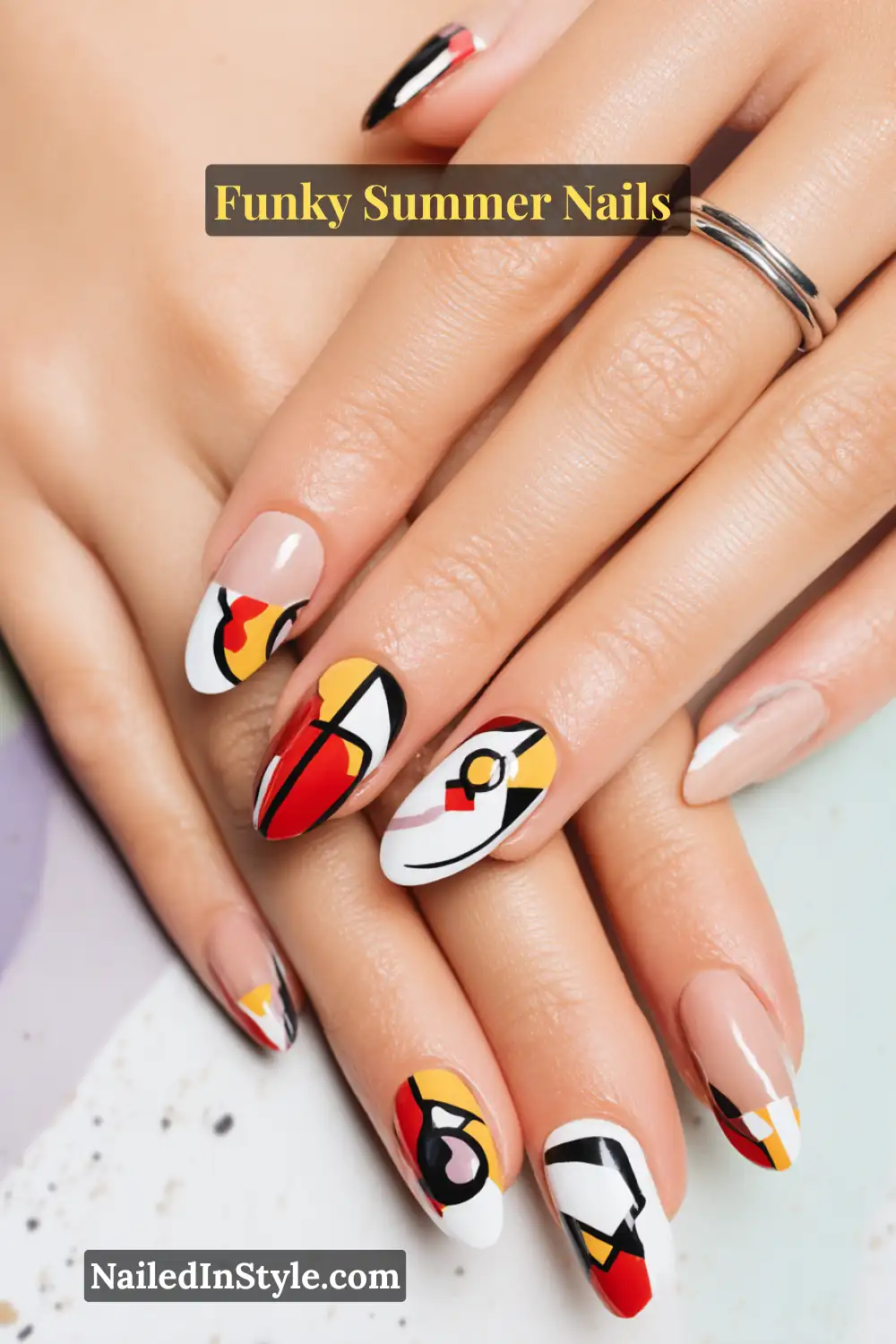 Close-up of almond-shaped nails with Picasso-inspired abstract designs in black, white, red, and yellow. Bold doodle-style patterns create a modern art vibe with geometric accents and color blocking.