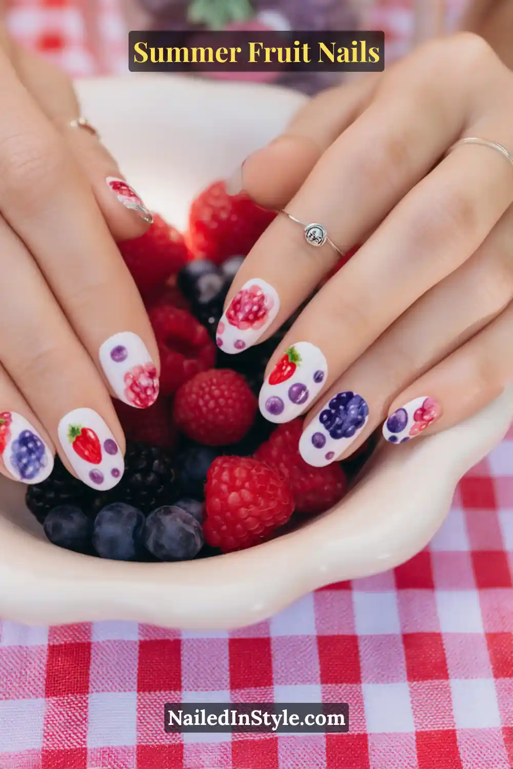 Oval nails with a crisp white base featuring strawberries, raspberries, blueberries, and blackberries in detailed nail art.