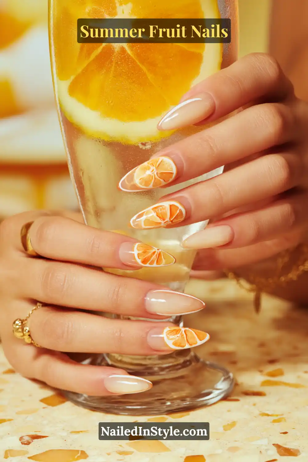 Almond-shaped nails with lemon and orange slice designs along the tips.