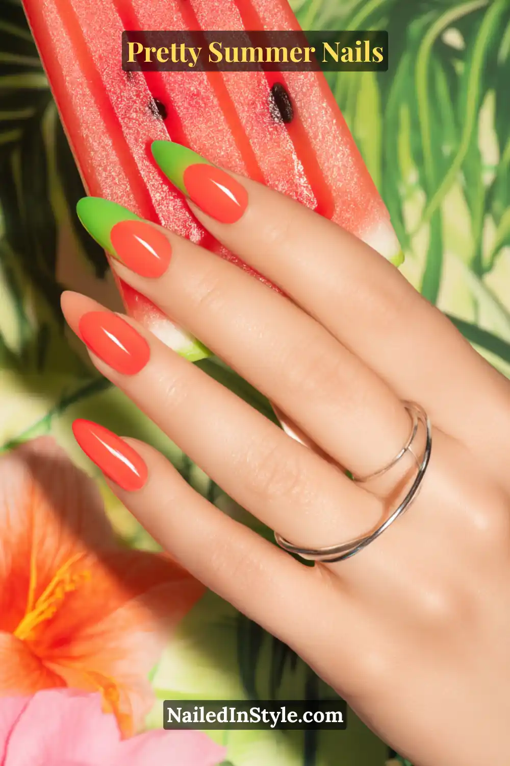 Close-up of hand with almond-shaped nails in coral polish and green tips, resembling watermelon popsicle colors.