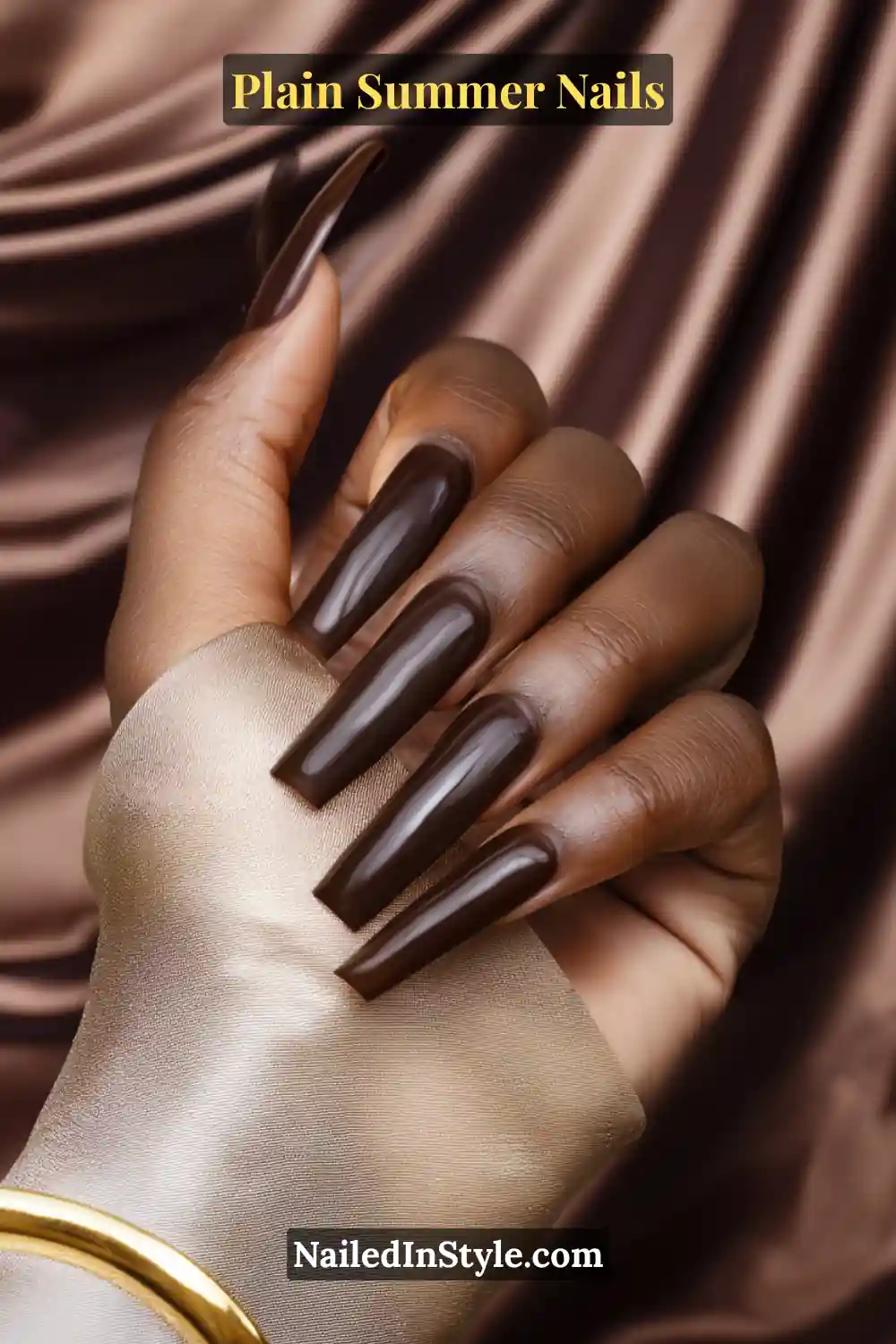 Plain Summer Nails 2025: Simple & Timeless Beauty 11 Close-up of deep skin tone hands with long coffin-shaped nails painted in bronze nude and cocoa brown polish, enhancing depth and richness.