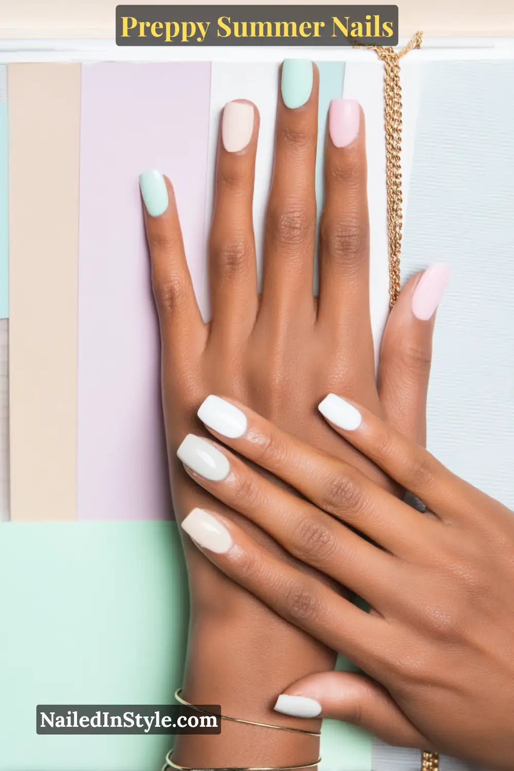 Hand with pastel summer nails in mint, pink, lilac, and white on medium-deep skin tone.